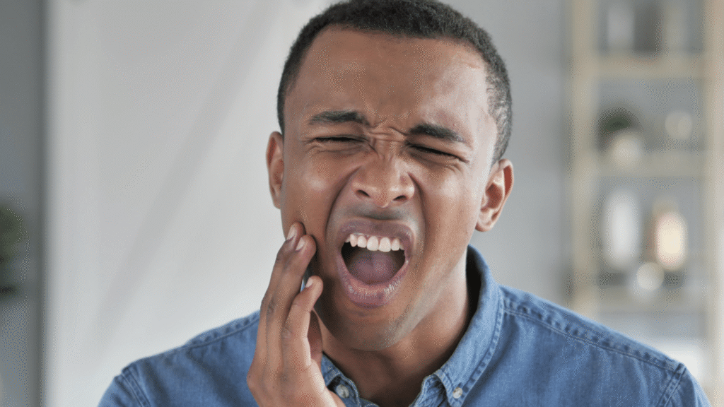 man holding his jaw in pain from a toothache before treatment at Northside Family Dentistry in O'Fallon, MO
