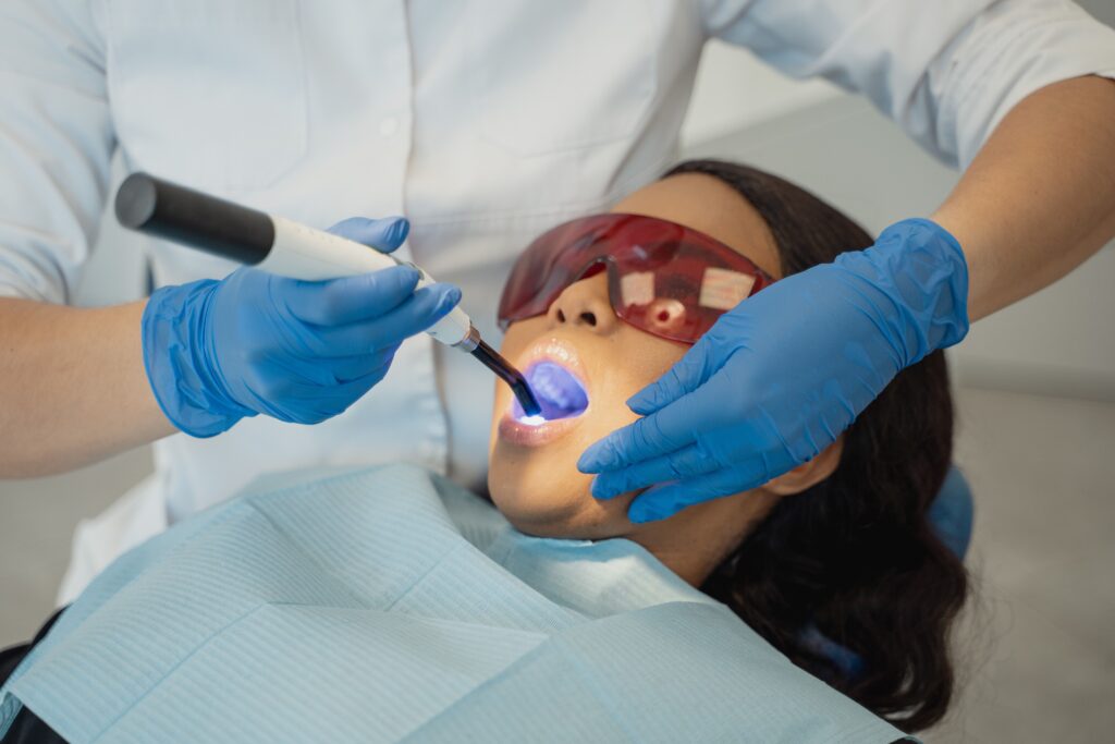 Dentist providing a professional fluoride treatment during a routine preventive dental visit to help strengthen teeth and reduce the risk of cavities.